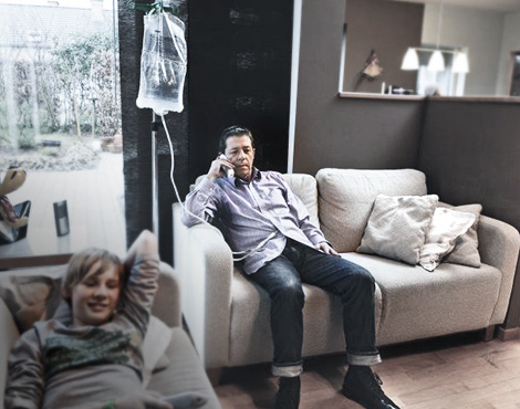 Patient performing CAPD at home while talking on the phone, with their son nearby