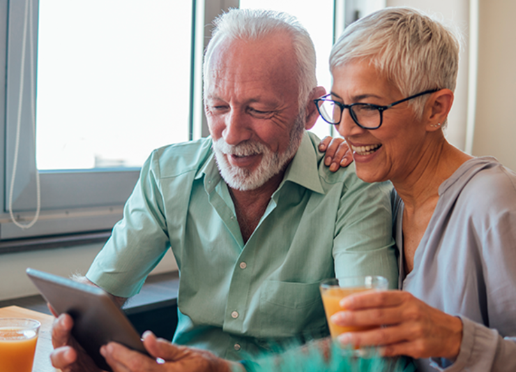 Man and woman sitting in their home, talking and enjoying a cup of coffee